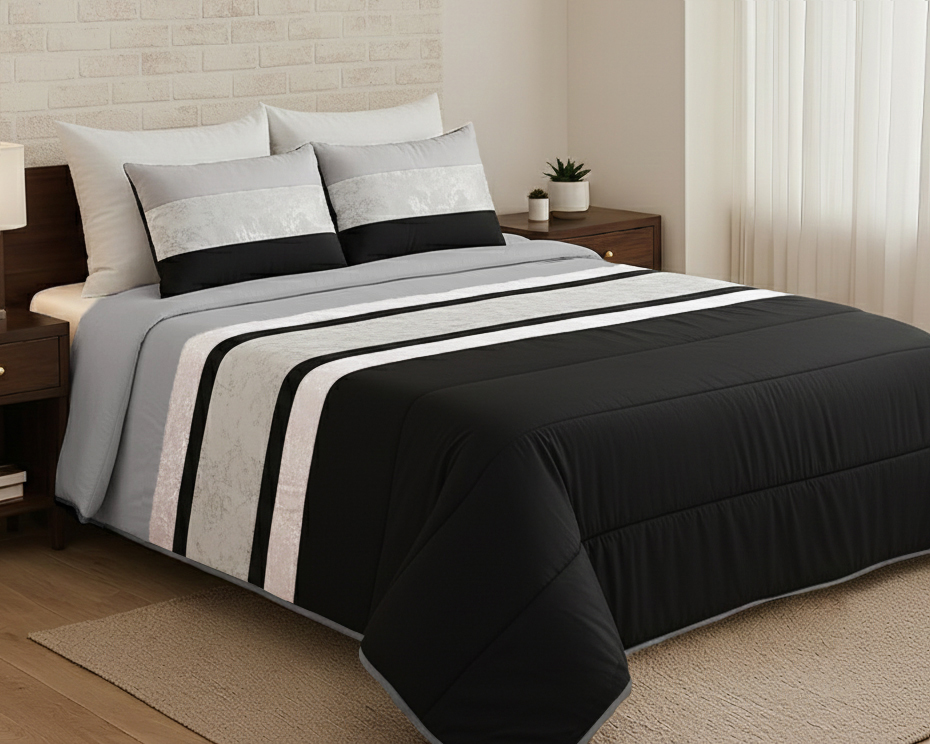 Cama com edredão e almofadas em riscas preto, cinza e branco, quarto com móveis de madeira escura e parede branca