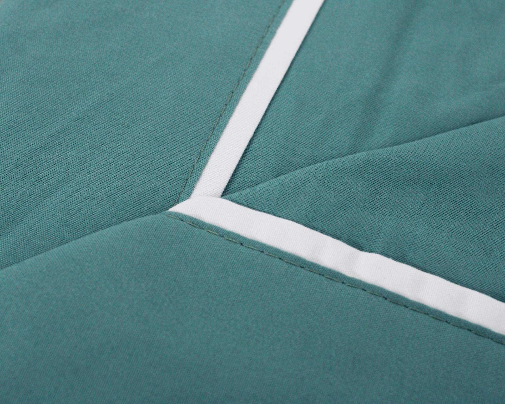 Tecido verde-azulado com risca branca e costuras