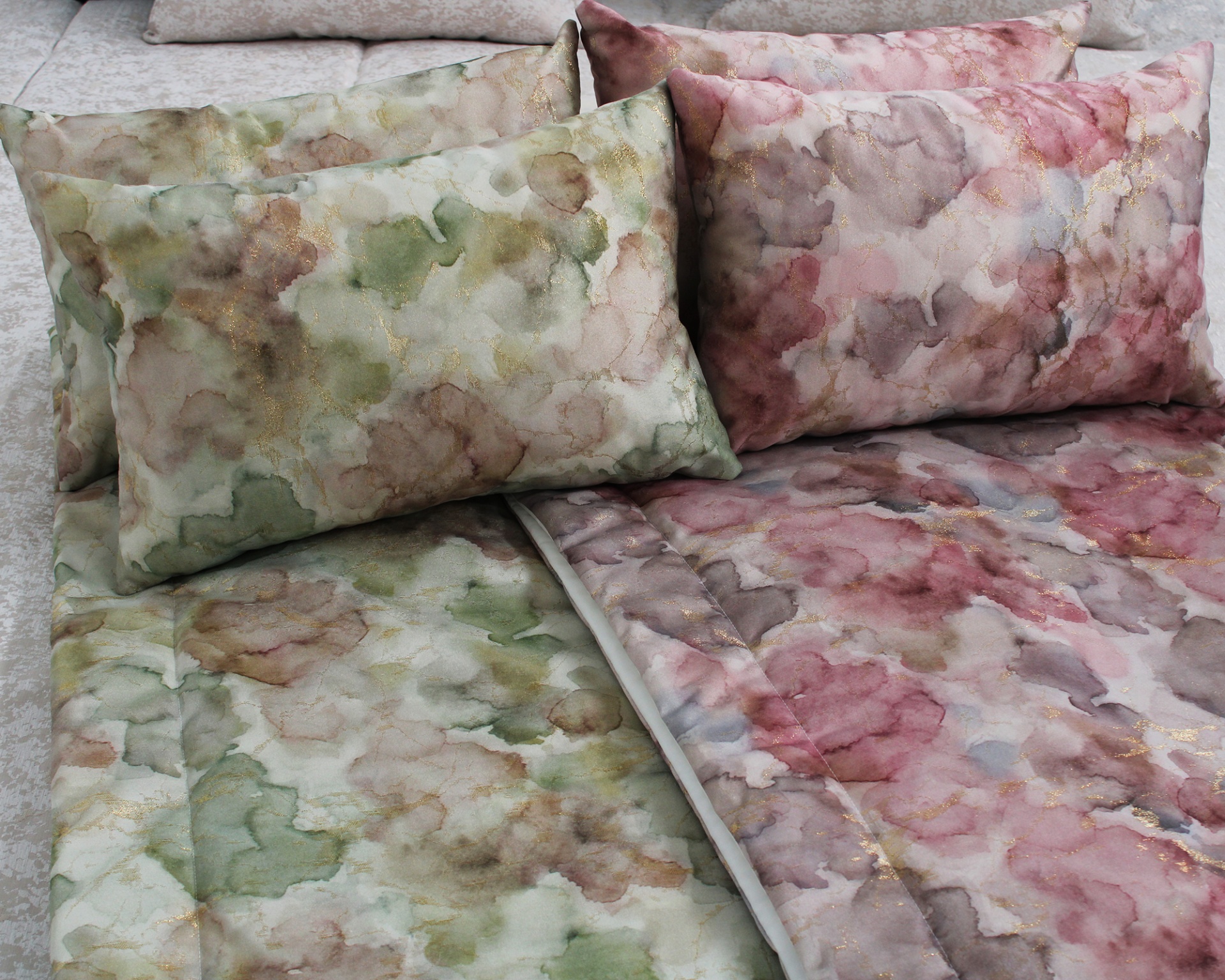 conjunto de roupa de cama com padrão aquarelado em tons verdes e rosas