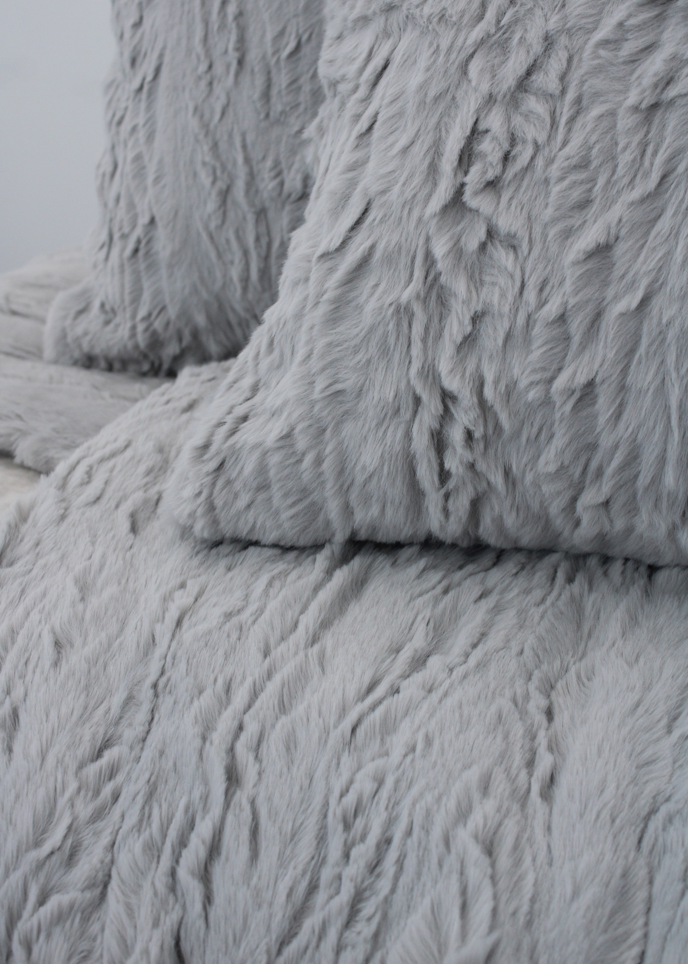 Almofadas e manta felpudas cinzentas