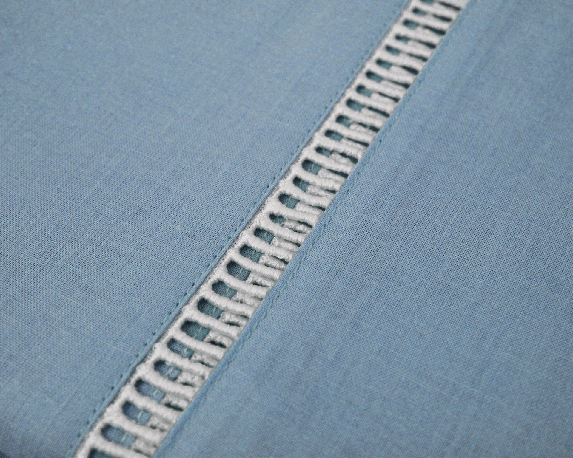 tecido azul-claro com detalhe decorativo branco tipo renda