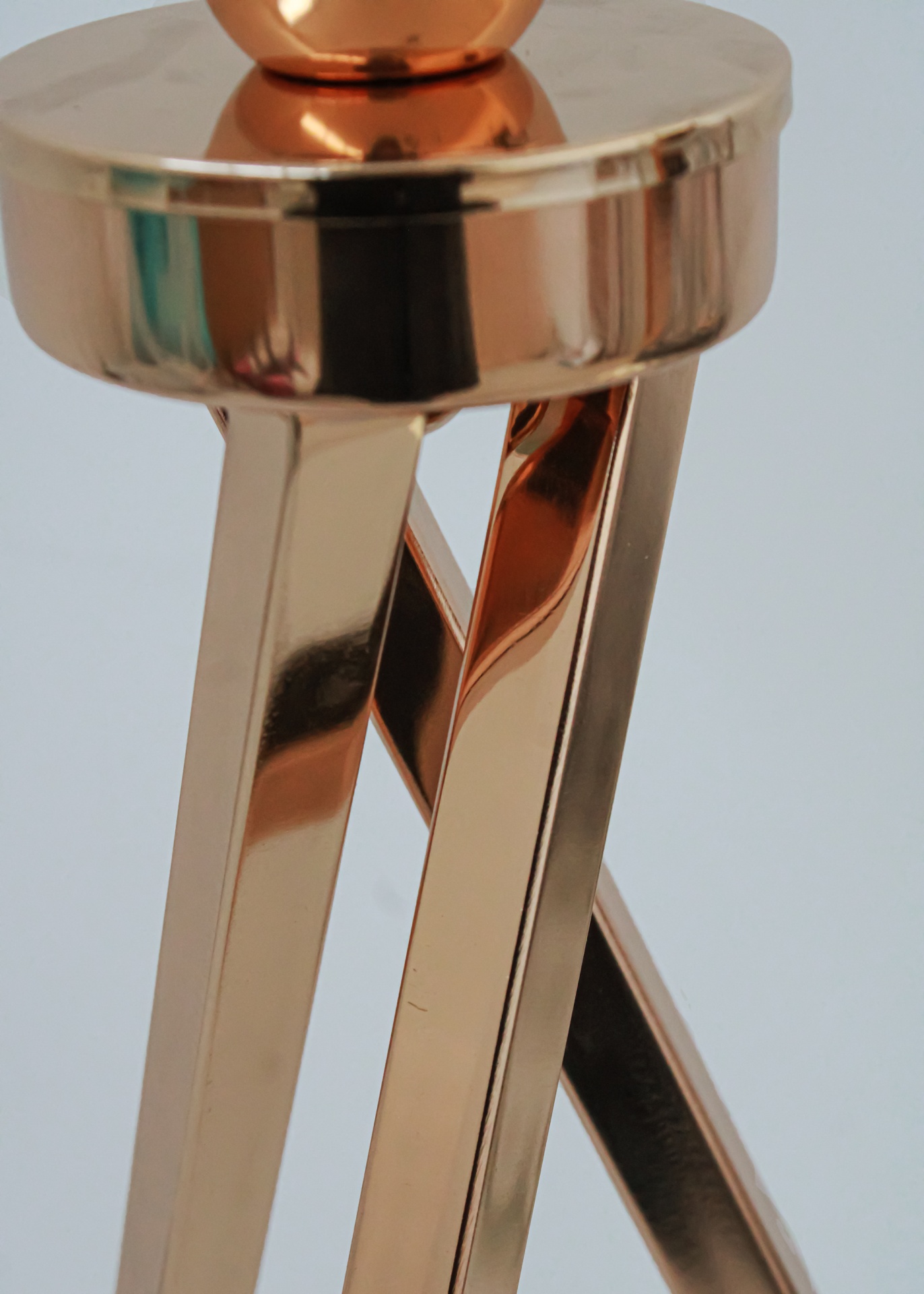 Base metálica dourada brilhante com três pernas retangulares