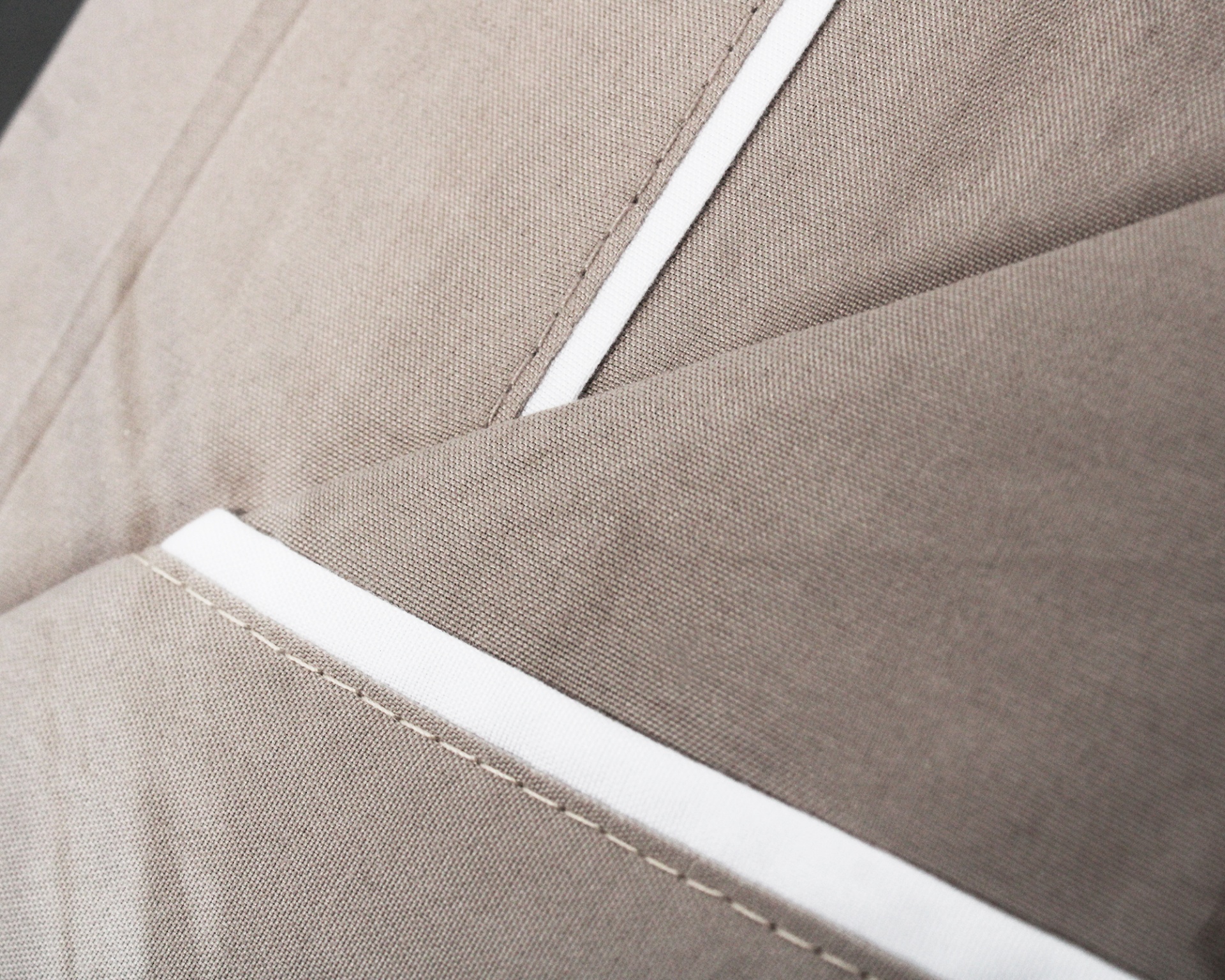 Tecido bege com costura branca e textura lisa