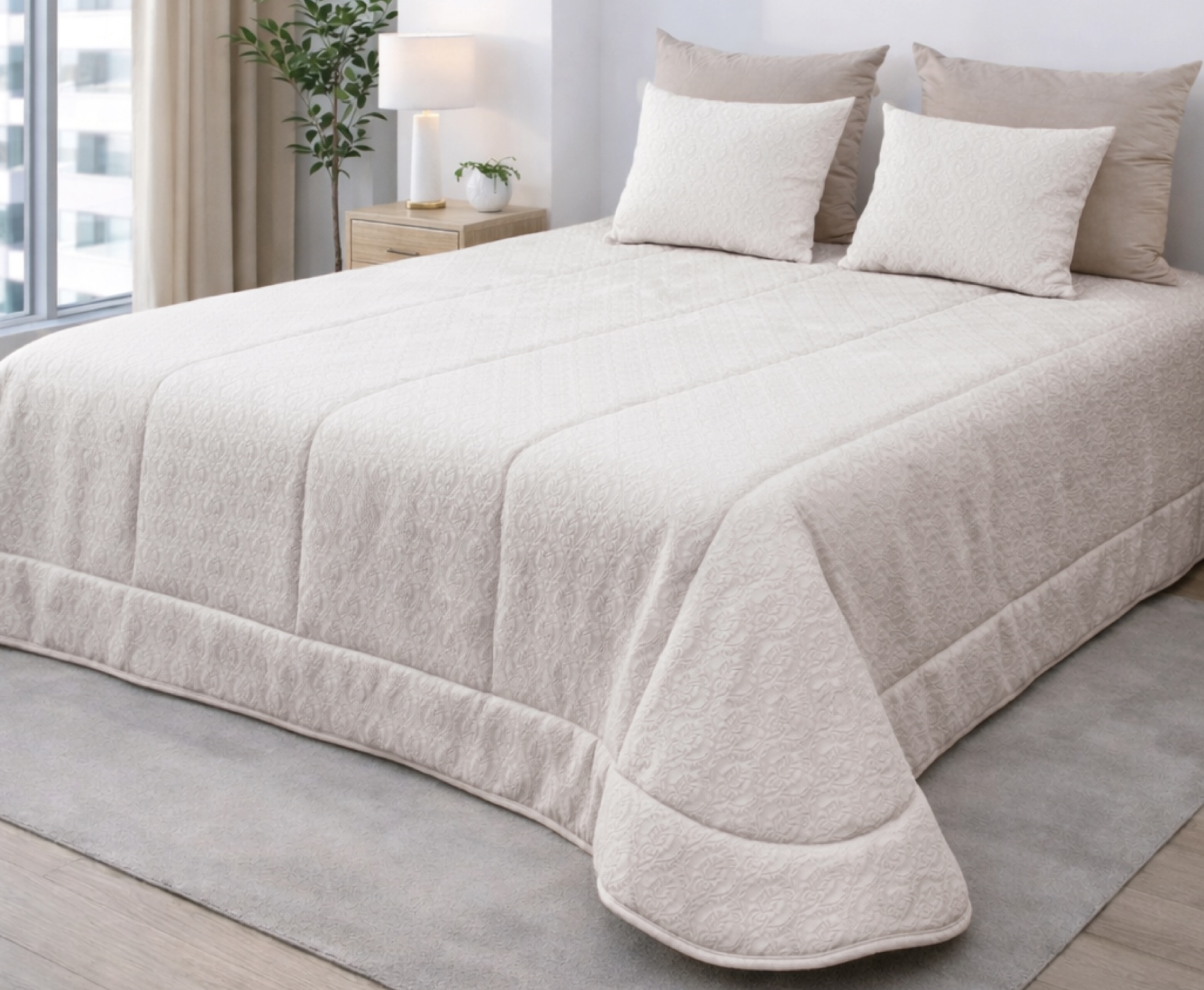 Colcha bege claro com padrão floral e almofadas decorativas numa cama em quarto minimalista