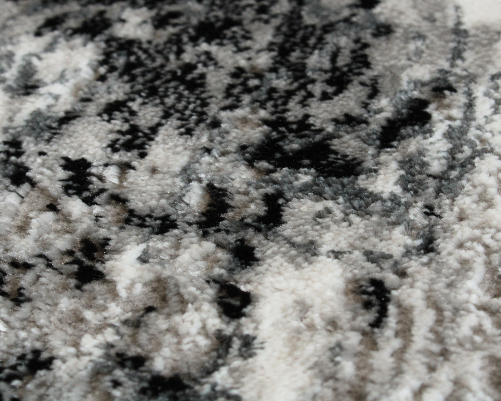 Tapete felpudo cinza, preto e branco com padrão abstrato