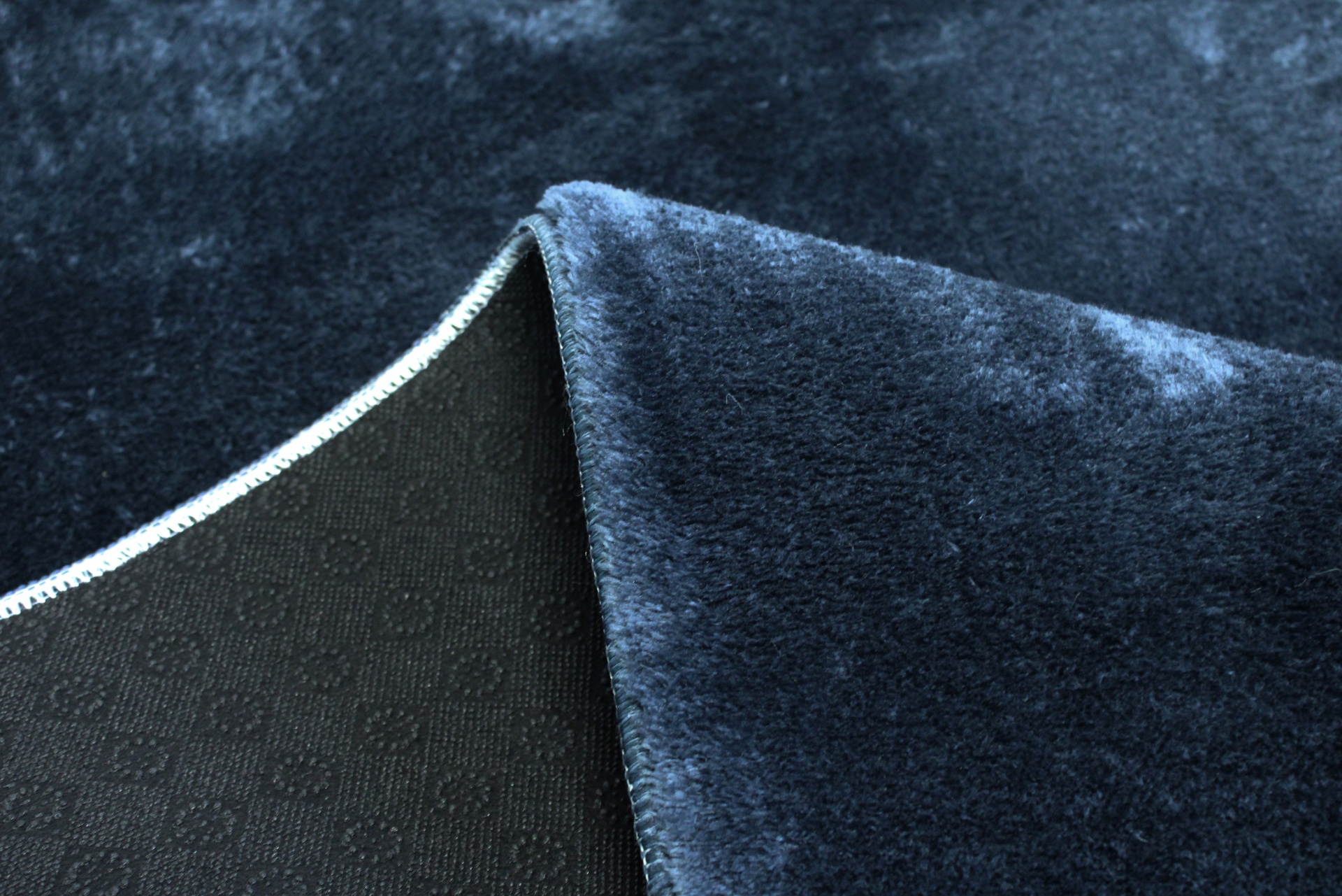 Tecido azul escuro felpudo com verso preto e padrão de círculos