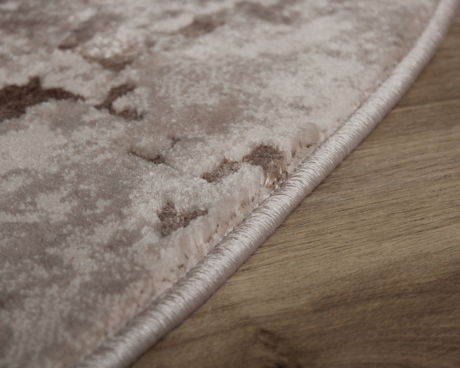 Tapete com padrão abstrato em castanho claro, bege e creme com borda costurada em tom bege