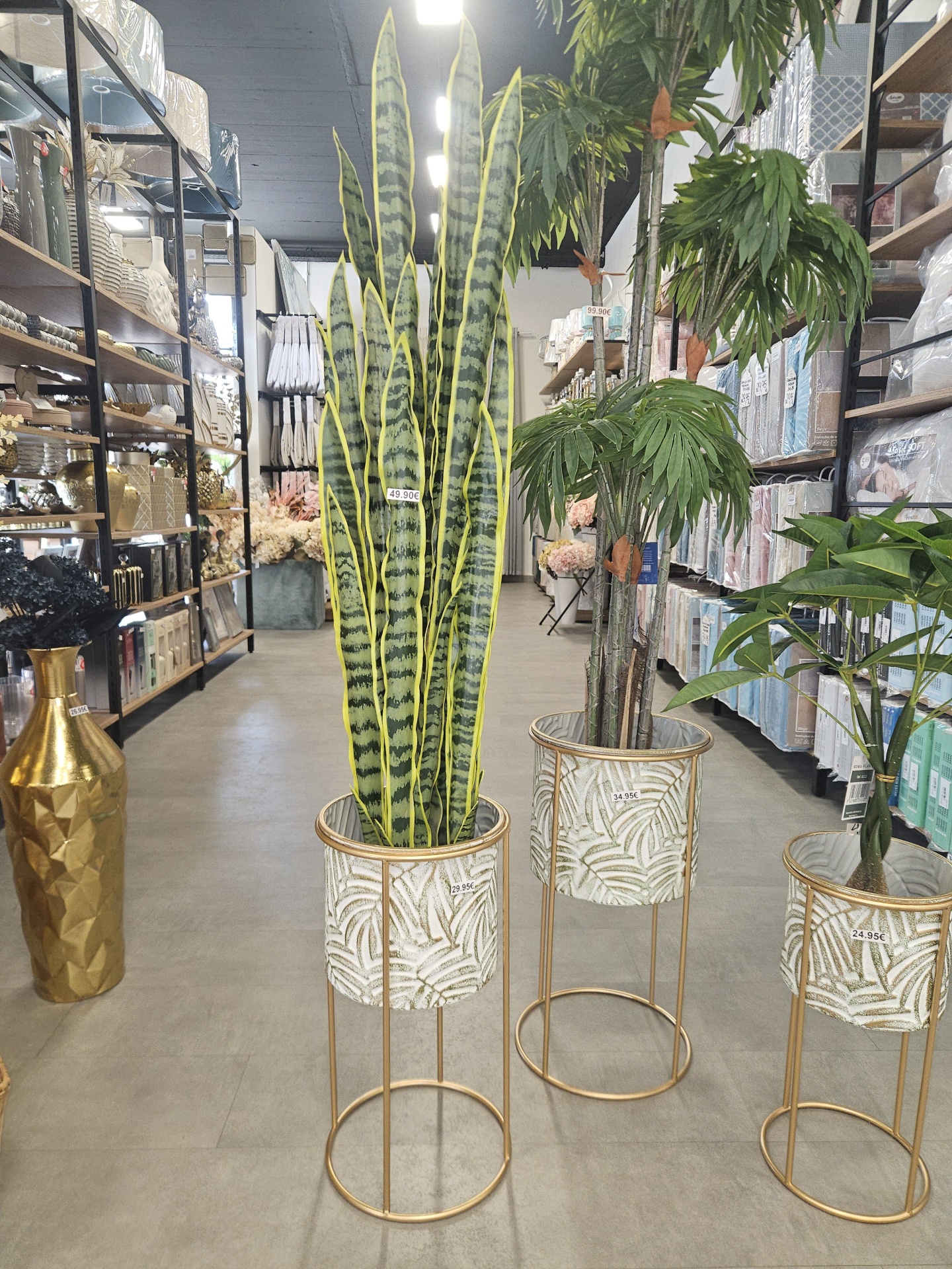 Plantas artificiais em vasos decorativos com etiquetas de preço numa loja de artigos para casa