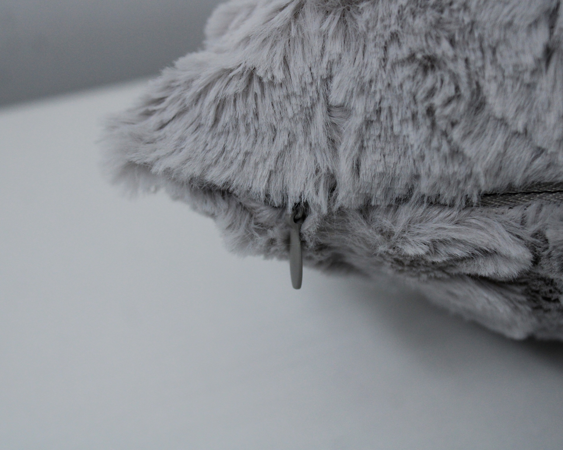 Almofada cinzenta de pelo com fecho