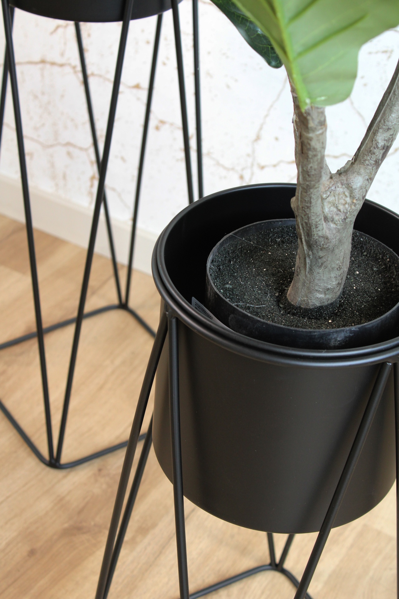 Vaso de plantas em metal preto com suporte em pernas finas