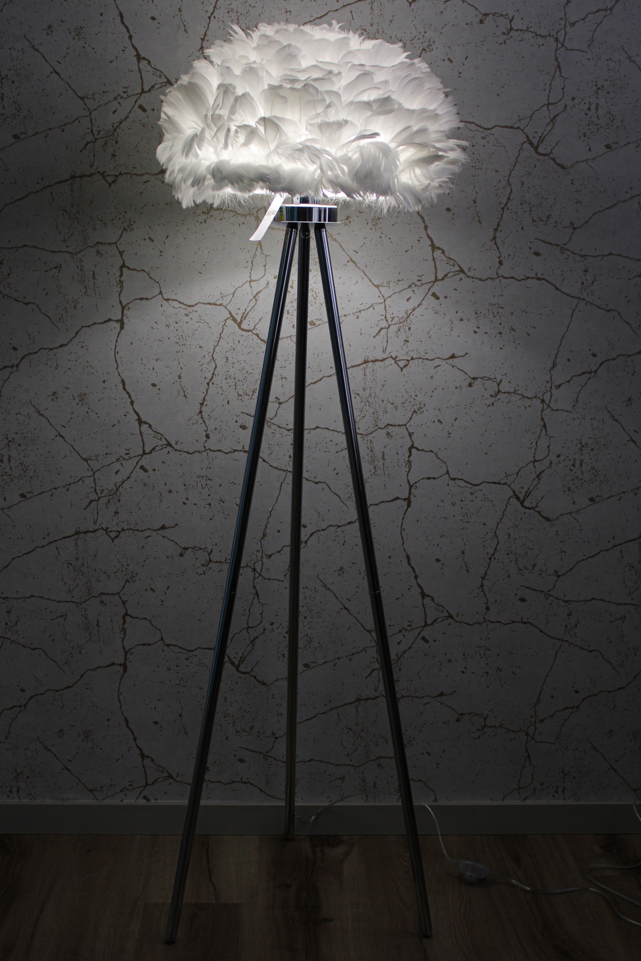 Candeeiro de pé tripé preto com abajur de penas brancas iluminado