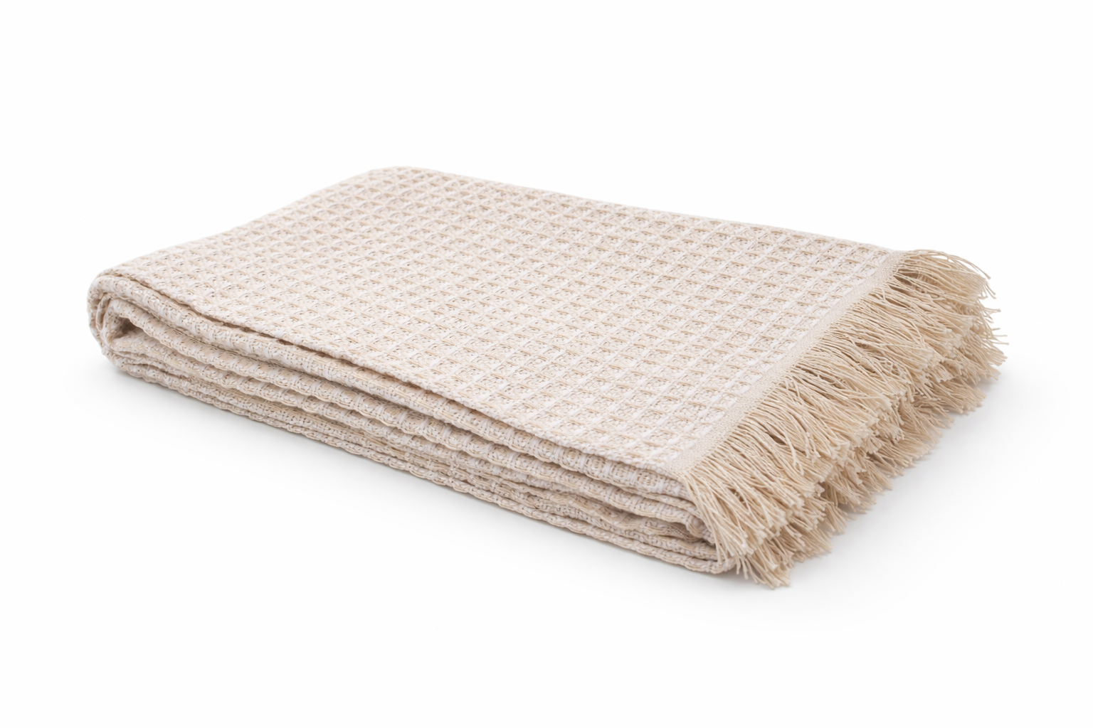 Manta ou toalha dobrada de algodão bege com padrão em waffle e franjas