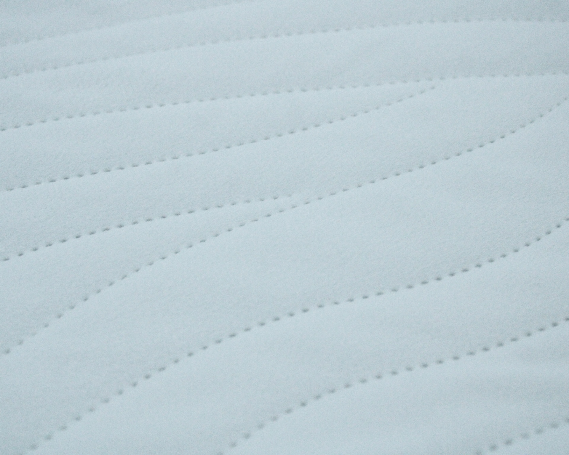 Tecido branco com padrão ondulado acolchoado