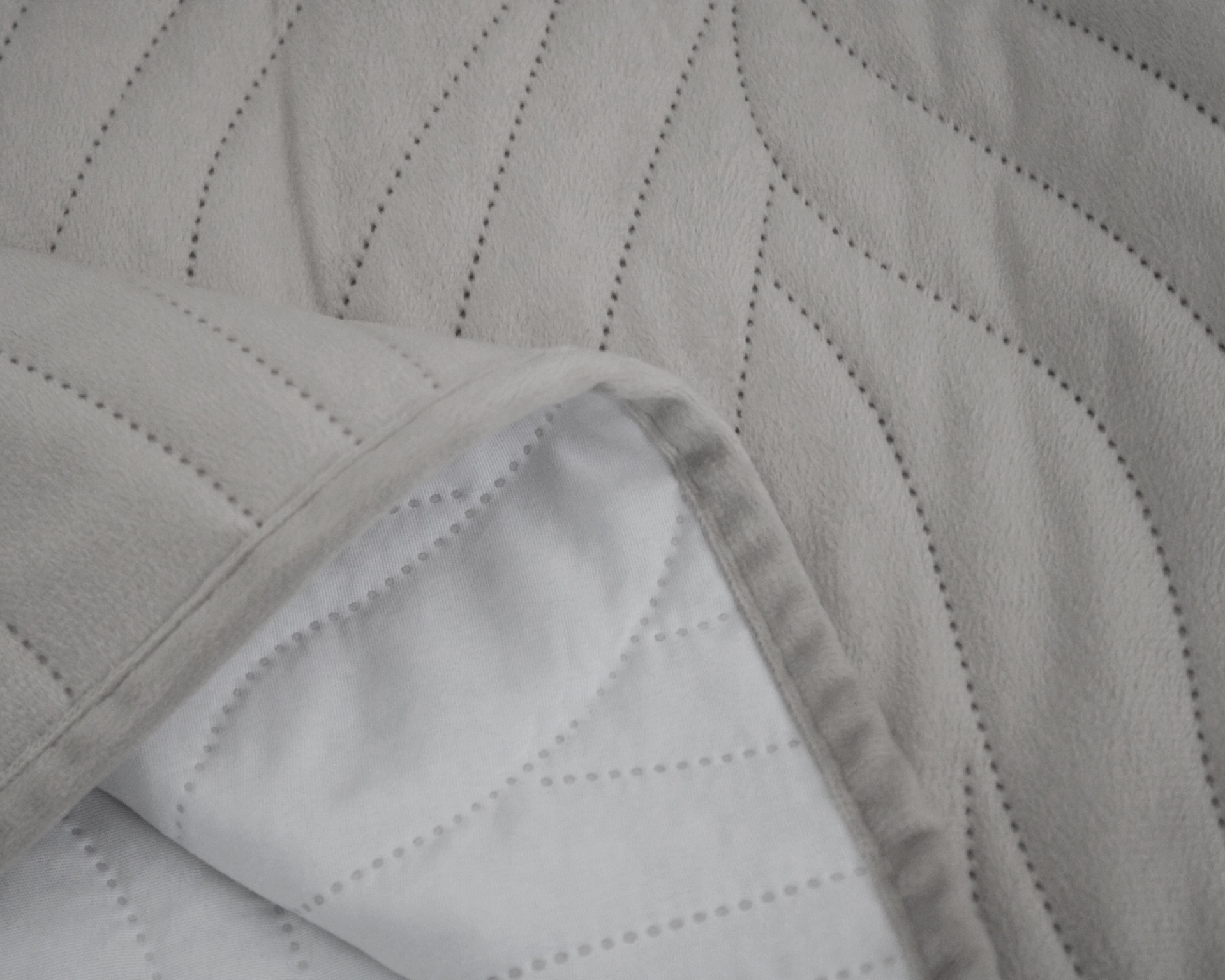 Tecido acolchoado cinza claro e branco com padrões de costura