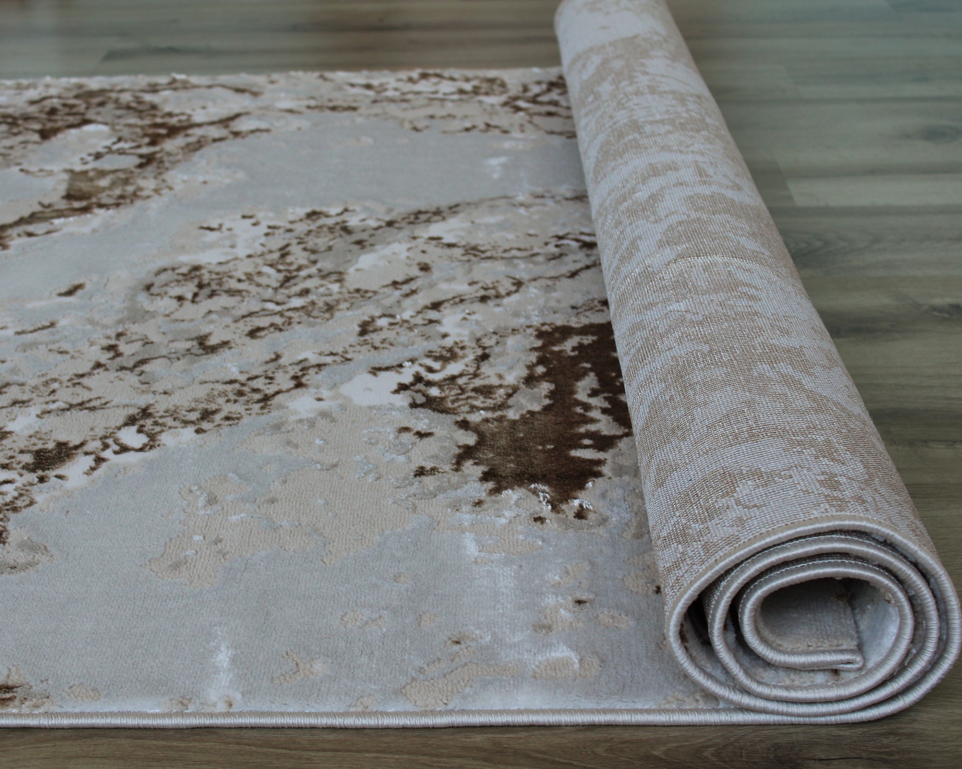 Tapete bege e castanho desenrolado sobre chão de madeira clara