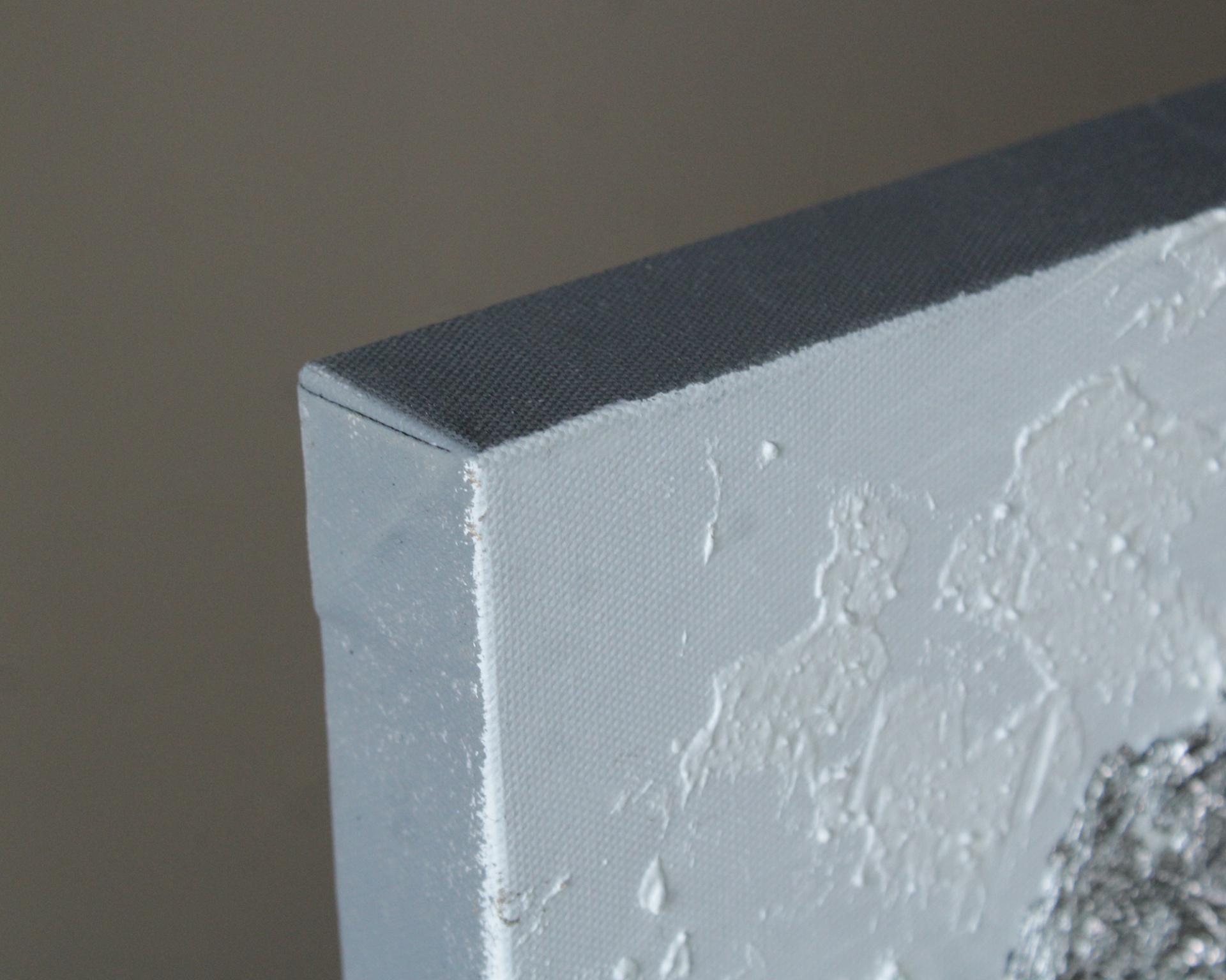 Canto de uma tela branca texturada com tinta espessa em relevo