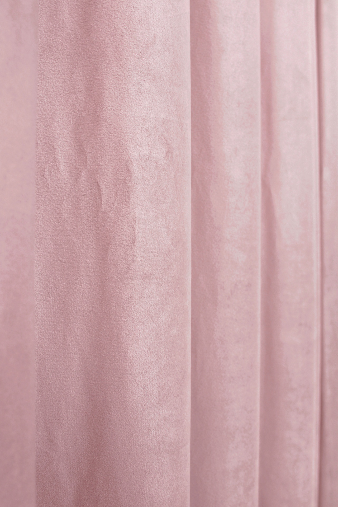 Cortina rosa claro com textura aveludada e dobras verticais