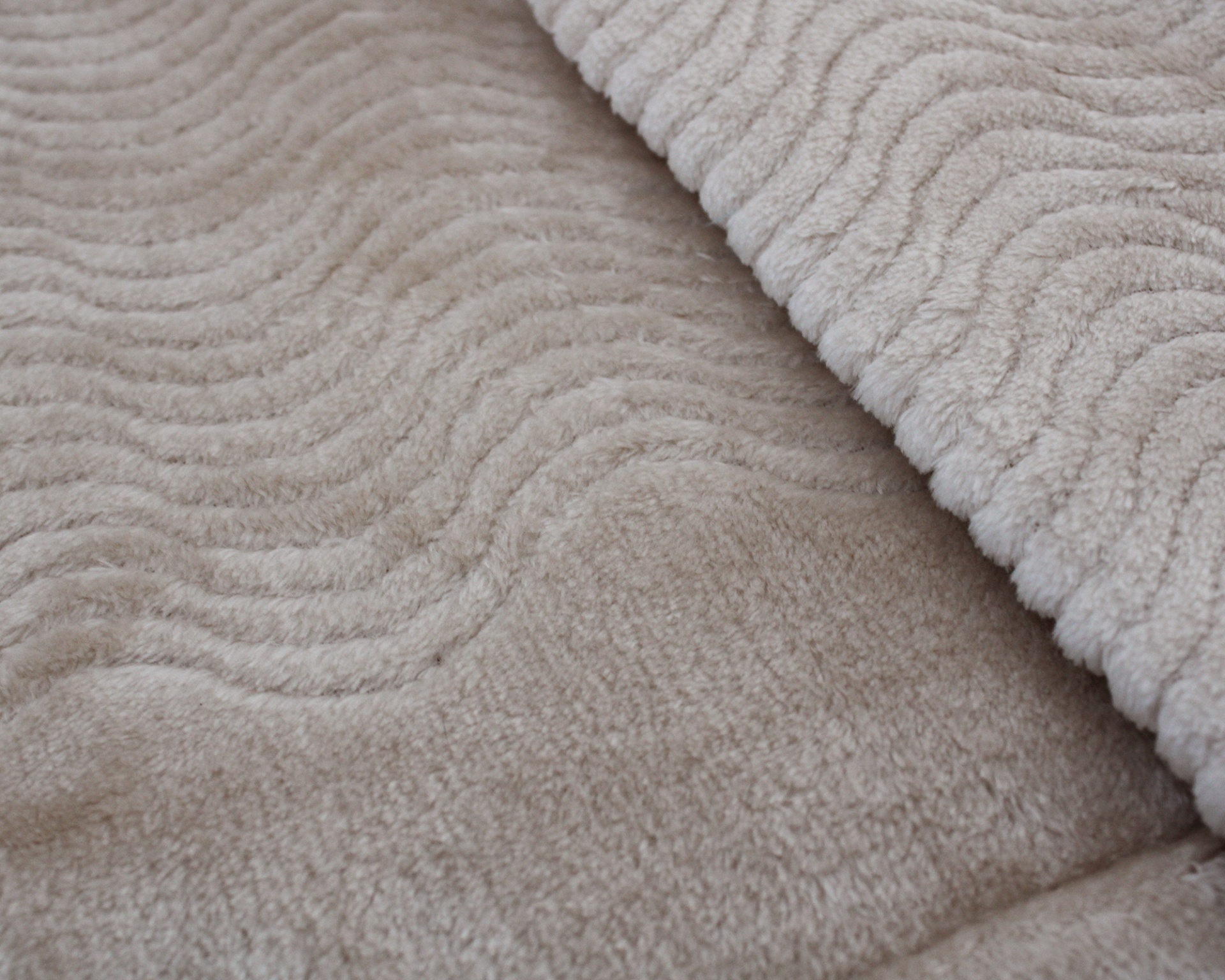 Tapete ou manta bege claro com padrão ondulado em relevo