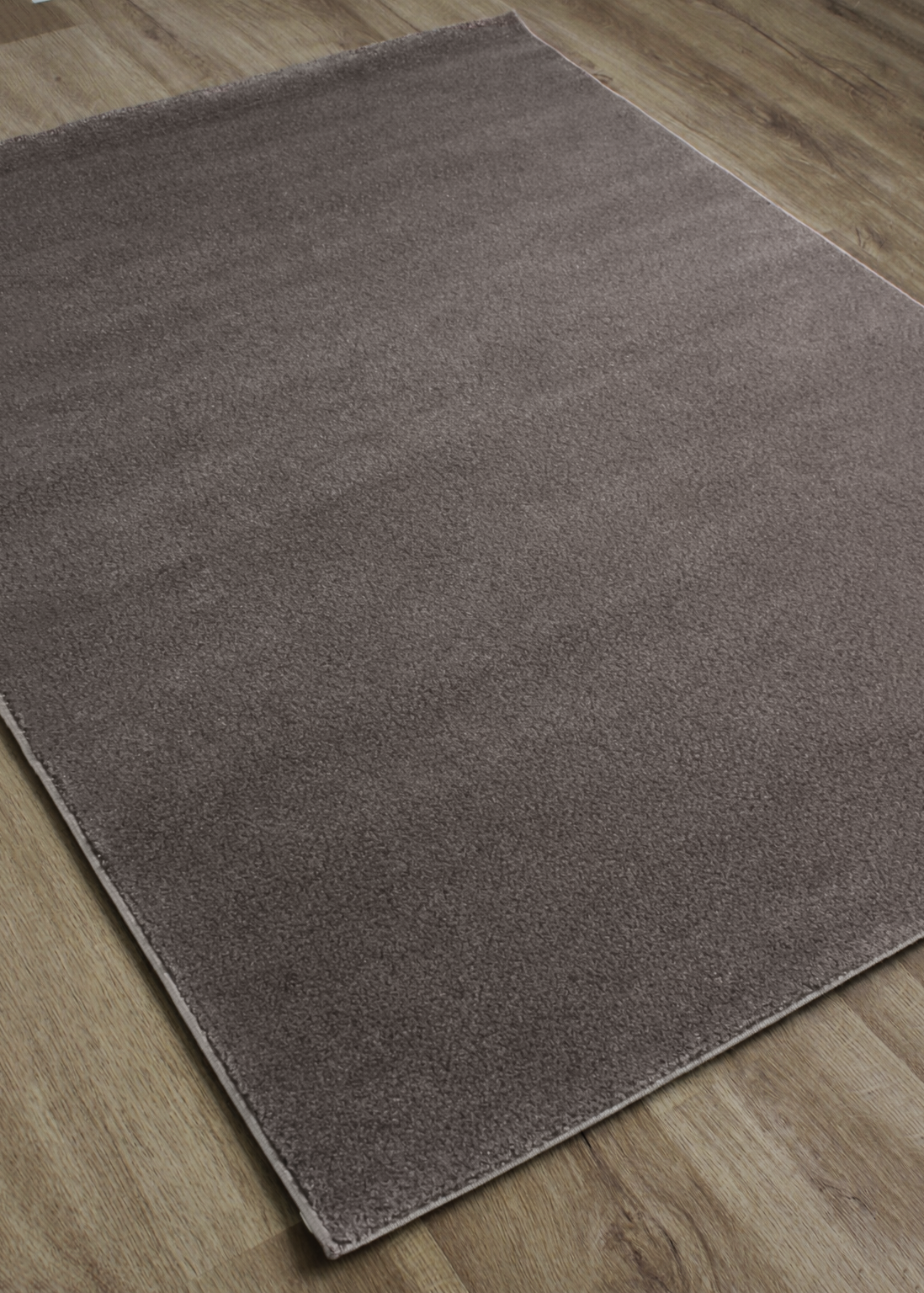 Tapete castanho macio sobre chão de madeira clara