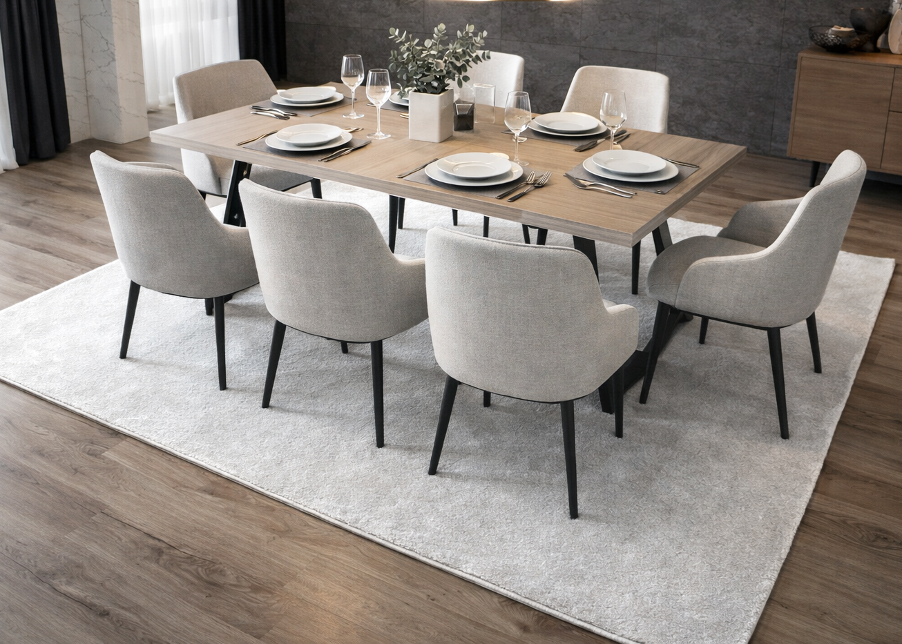 Mesa de jantar em madeira com cadeiras estofadas cinza claro e decoração de louça e plantas.