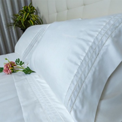 Conjunto de roupa de cama branca com bordados decorativos