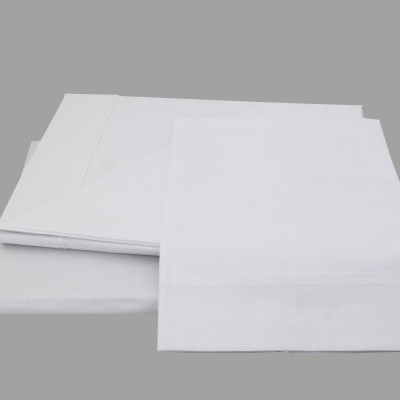 Conjunto de roupa de cama branca de algodão sobre superfície cinza