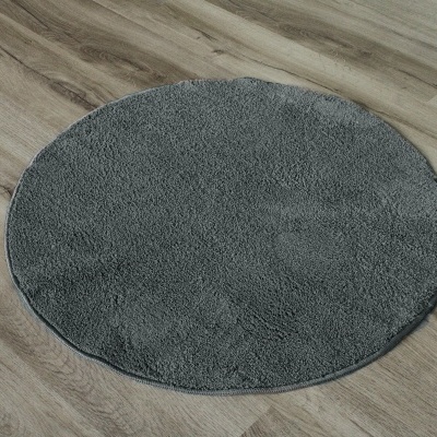 Tapete redondo cinzento sobre chão de madeira clara