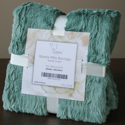 Manta de pelo borrego verde agua enrolada com etiqueta