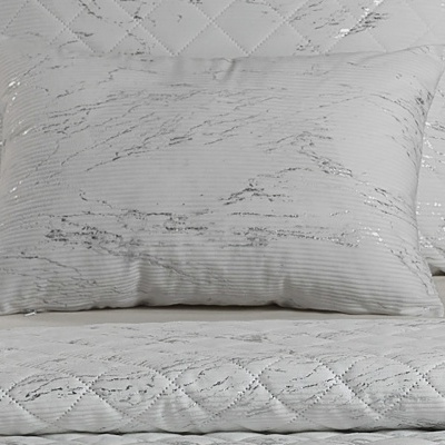 Conjunto de roupa de cama branca com padrão riscado cinza e textura matelassada
