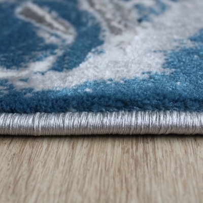 tapete azul e cinza com borda cinza prateada sobre piso de madeira clara