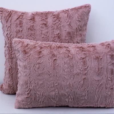 Conjunto de almofadas rosa felpudas em cima de superfície branca