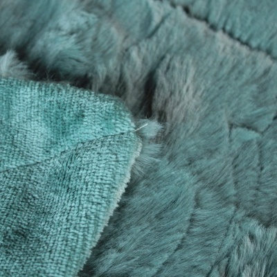 Tapete azul esverdeado com textura peluda e detalhe do tecido na parte de trás