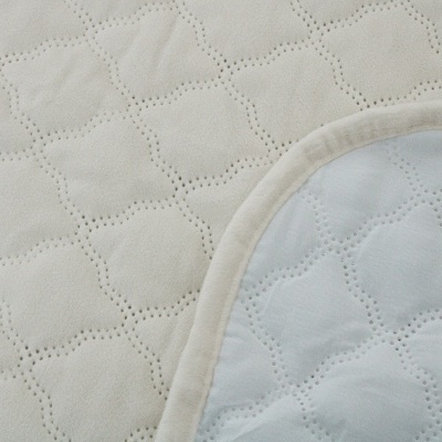 tecido acolchoado bege e branco com costura arredondada
