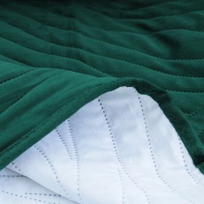 Cobertor verde escuro acolchoado com interior branco visível