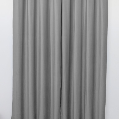 Cortina cinzenta lisa pendurada numa barra metálica com ilhóses