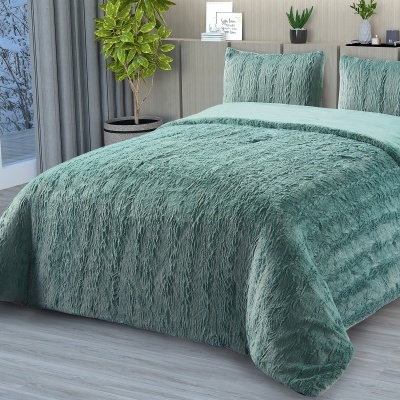 Cama com cobertor e almofadas verdes felpudos num quarto moderno com plantas e janela para paisagem nevada