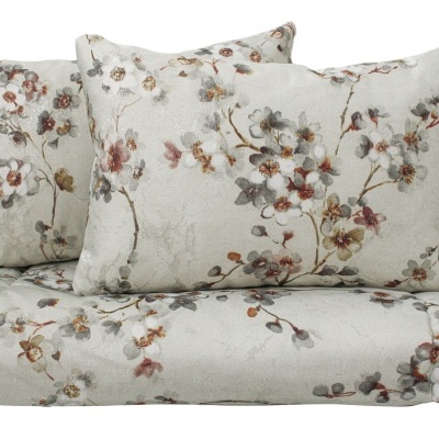 Conjunto de roupa de cama com padrão floral em tons suaves sobre fundo cinza claro