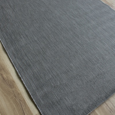 Tapete cinza de malha sobre chão de madeira clara