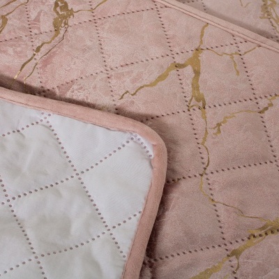 Colcha rosa com padrão quadriculado e detalhes dourados