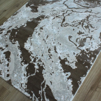 Tapete abstrato cinza, branco e castanho no chão de madeira.
