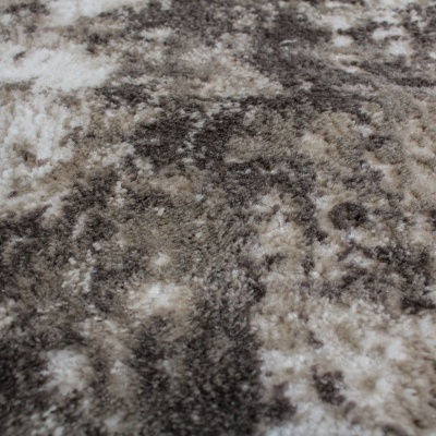 Detalhe de carpete felpudo com padrão abstrato cinza, bege e branco