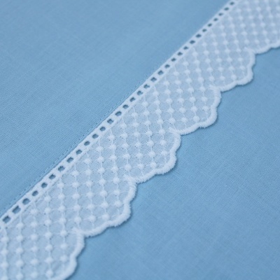 Tecido azul claro com renda branca decorativa ondulada