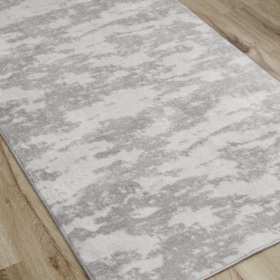 Tapete rectangular cinza claro e branco sobre chão de madeira clara