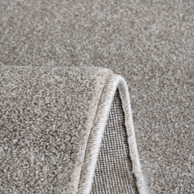 Tapete bege de tecido sintético com bordas costuradas