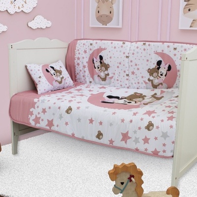 Cama branca infantil com roupa de cama estampada com ursos e estrelas, almofada com padrão igual, paredes cor-de-rosa e quadros de animais.