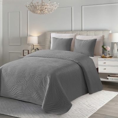 Cama com conjunto de cama cinzento texturizado num quarto neutro