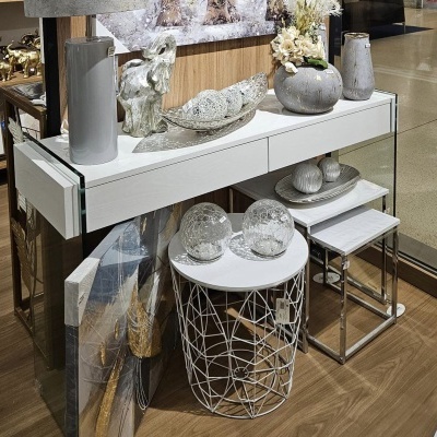 Móvel branco com tampo de vidro e objectos decorativos em loja