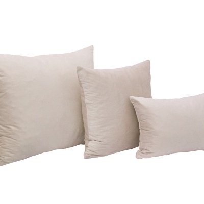 Três almofadas bege claro em vários tamanhos sobre fundo branco