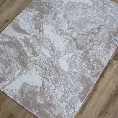 Tapete cinza e bege com padrão abstrato sobre chão de madeira clara