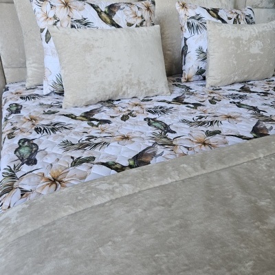 Conjunto de cama com almofadas em tecido cinza e fronhas floridas com pássaros.